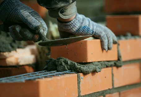 Brick courses being set along a full mortar bed